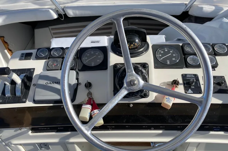 Slide: The Image of Helm of 1988 Luhrs Tournament 320 Convertible with steering wheel and navigation instruments. - 17