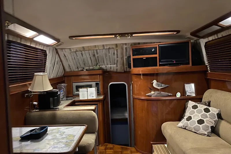 Slide: The Image of Interior of 1988 Luhrs Tournament 320 Convertible yacht with cozy seating and wooden decor. - 9