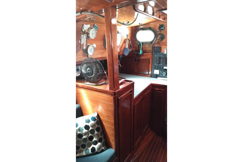 Slide: The Image of 1977 Westsail 32 yacht interior with wooden cabinetry, fan, and nautical instruments. - 10