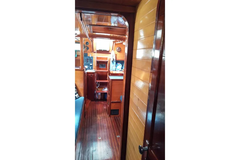 Slide: The Image of Interior view of a 1977 Westsail 32 sailboat with wooden paneling and nautical equipment. - 11