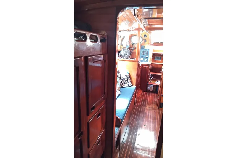 Slide: The Image of Interior of 1977 Westsail 32 sailboat with polished wood and blue seating. - 12