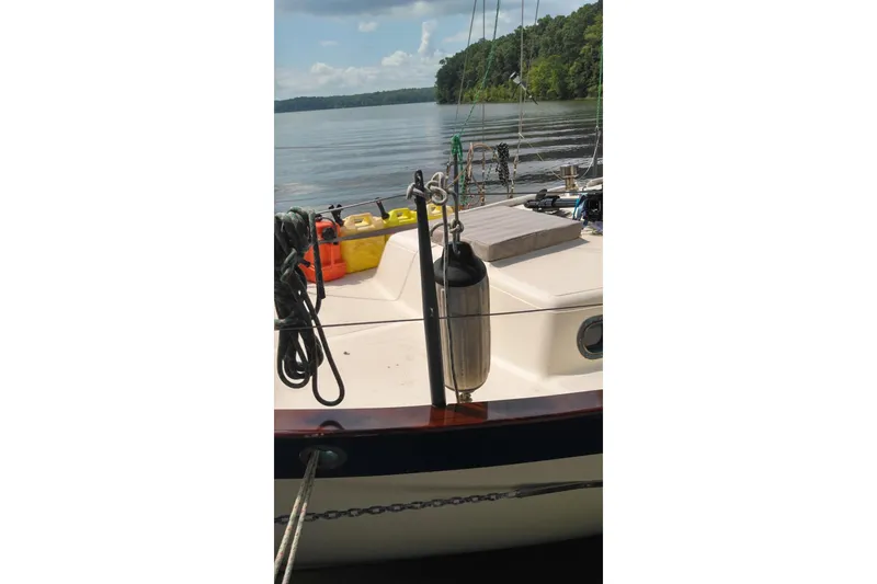 Slide: The Image of 1977 Westsail 32 sailboat deck with ropes and equipment on a calm lake. - 3
