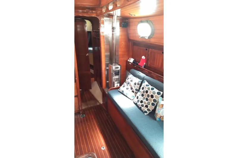 Slide: The Image of Interior of 1977 Westsail 32 sailboat with wooden paneling and cozy seating area. - 6