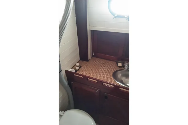 Slide: The Image of 1977 Westsail 32 boat interior with wooden cabinetry and stainless steel sink. - 9