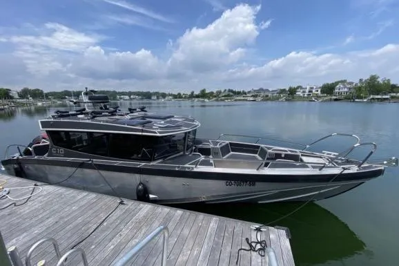 Slide: The Image of 2021 Viggo C10 boat docked on a serene lake under a partly cloudy sky. - 18