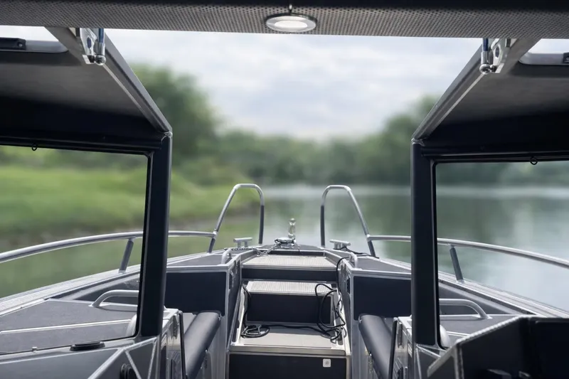 Slide: The Image of 2024 Viggo C10 boat interior with open canopy, overlooking serene water and greenery. - 8