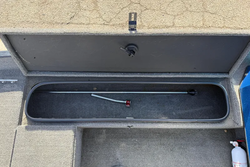 Slide: The Image of Open storage compartment in 1997 Tuffy 1700 ESOX MAGNUM boat, showing interior and tool. - 10
