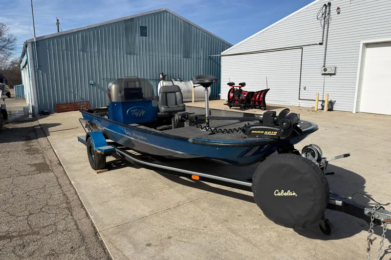 Slide: The Image of 1997 Tuffy 1700 ESOX MAGNUM fishing boat on trailer, parked outside industrial building. - 6