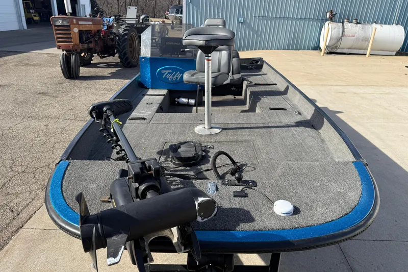 Slide: The Image of 1997 Tuffy 1700 ESOX MAGNUM fishing boat with trolling motor and seating, parked outdoors. - 7