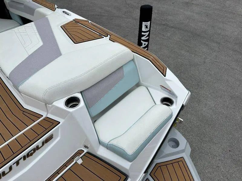 Slide: The Image of 2022 Nautique G23 boat seat with wood trim and cup holders. - 22