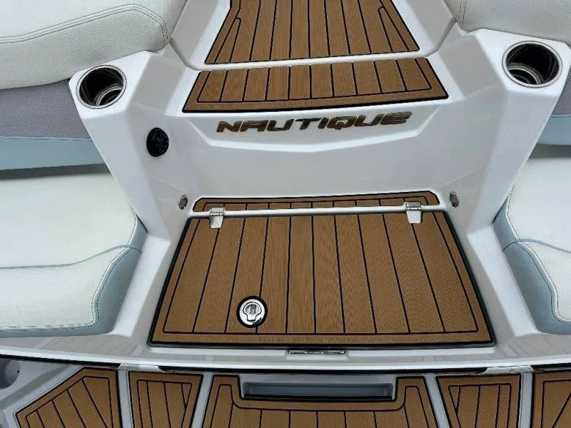 Slide: The Image of Nautique G23 2022 boat with wood-look deck and cup holders. - 24