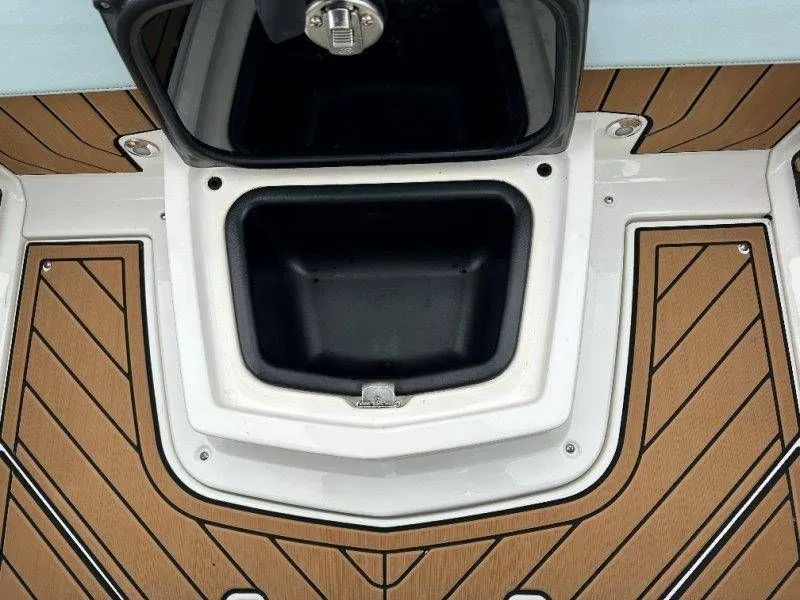 Slide: The Image of Nautique G23 2022 storage compartment with wood-patterned deck. - 37