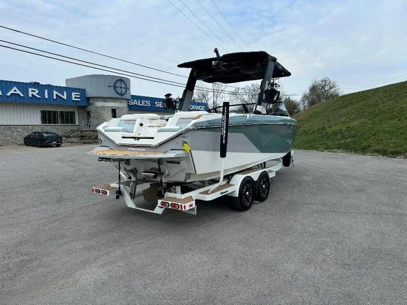 Slide: The Image of 2022 Nautique G23 boat on trailer outside a marine shop. - 7