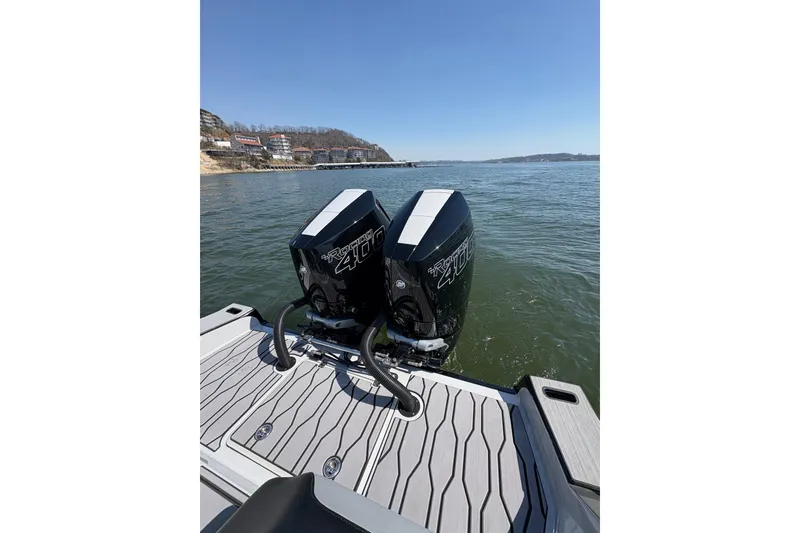 Slide: The Image of 2024 Sunsation 32 CCX boat with twin outboard engines on a calm lake. - 12