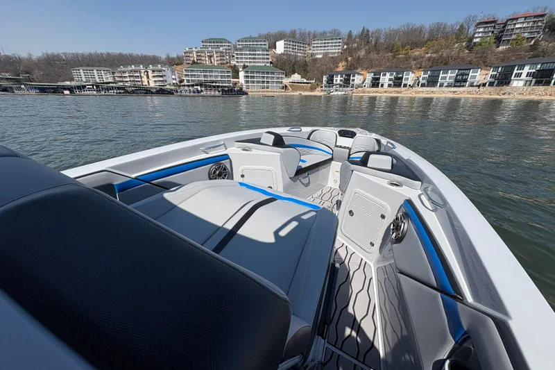 Slide: The Image of 2024 Sunsation 32 CCX boat interior with modern seating, on a scenic waterfront. - 17