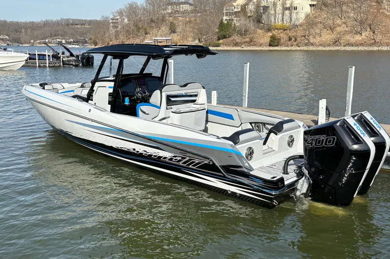 Slide: The Image of 2024 Sunsation 32 CCX boat with twin Mercury Racing 400 engines on a calm lake. - 2