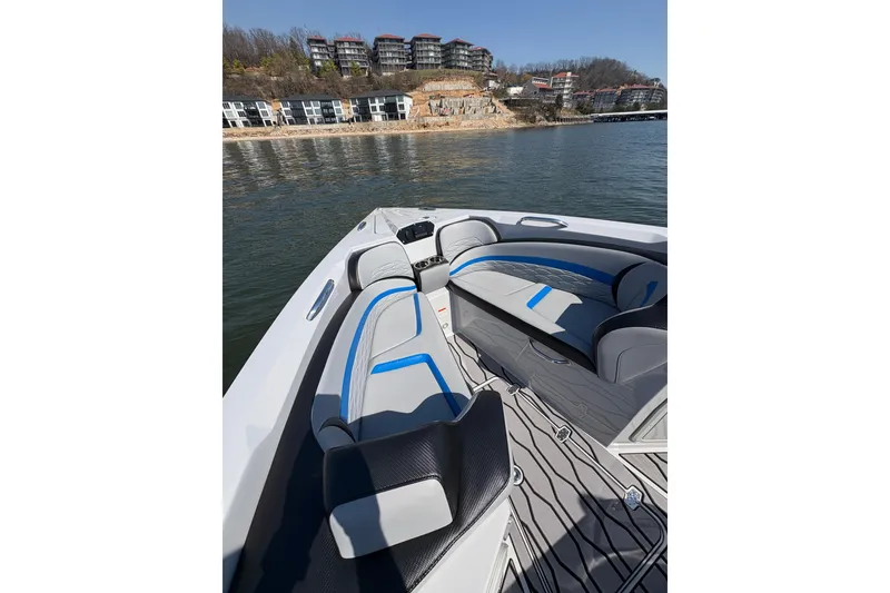 Slide: The Image of 2024 Sunsation 32 CCX boat interior with stylish seating, docked near waterfront buildings. - 21