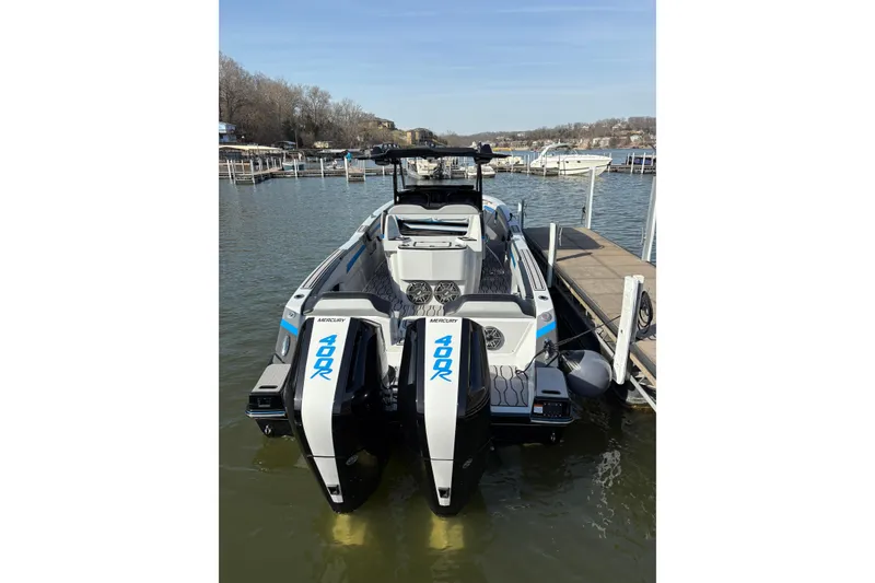 Slide: The Image of 2024 Sunsation 32 CCX boat with dual Mercury 400R engines docked at a marina. - 9