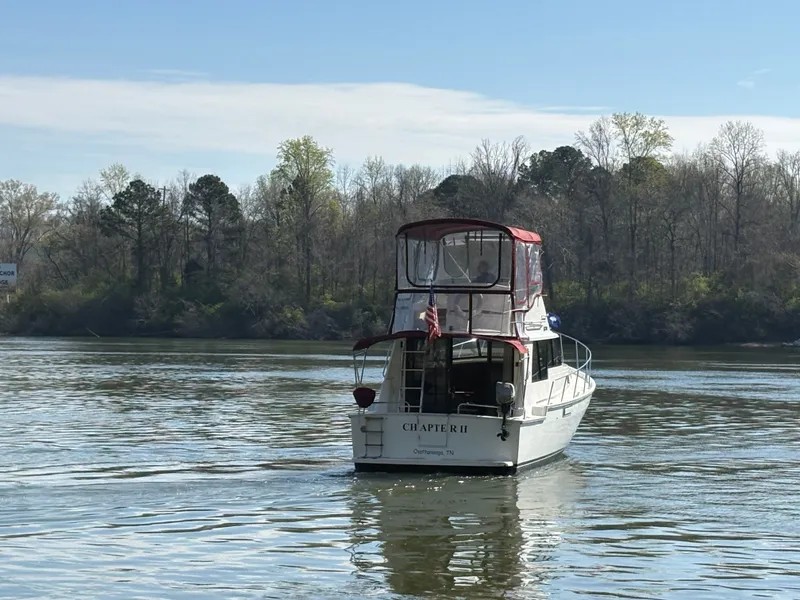 Slide: The Image of 1983 Mainship 34 Mark III boat on calm river. - 3