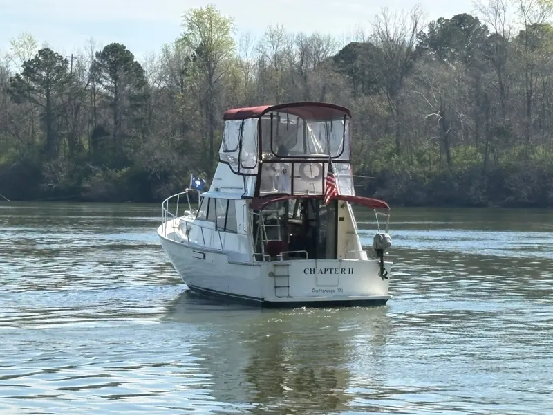 Slide: The Image of 1983 Mainship 34 Mark III boat on calm river. - 4