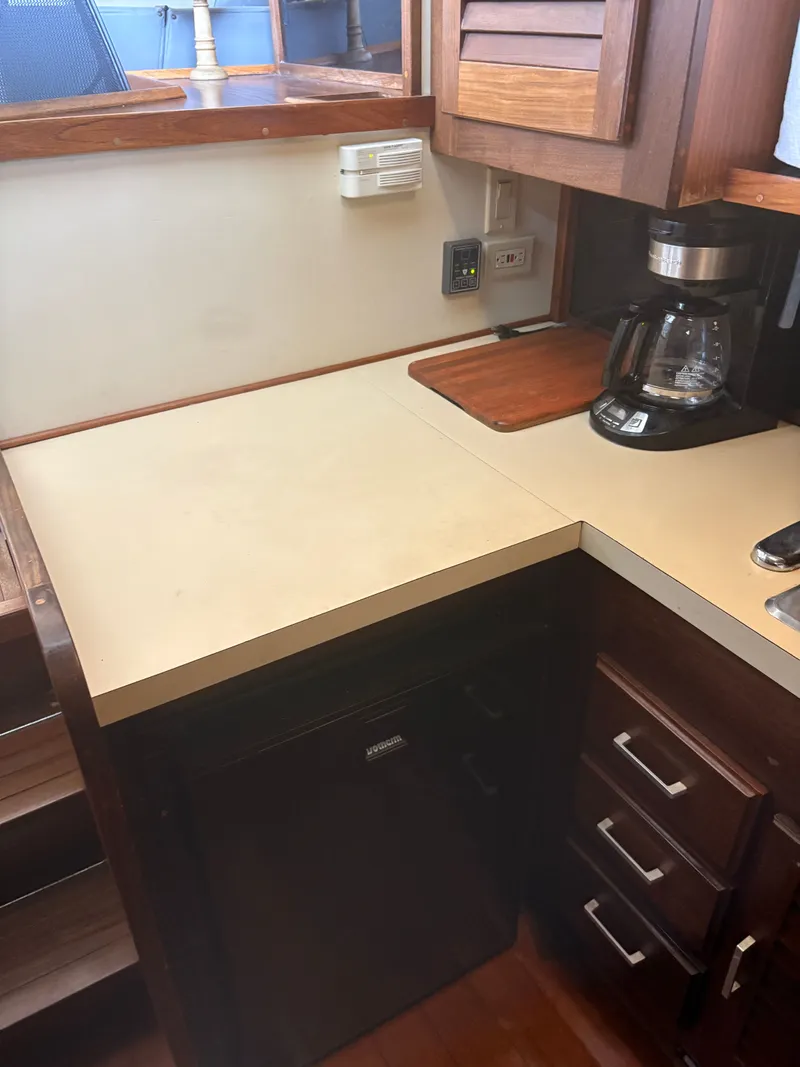 Slide: The Image of Galley on 1983 Mainship 34 Mark III with coffee maker and wooden cabinets. - 49