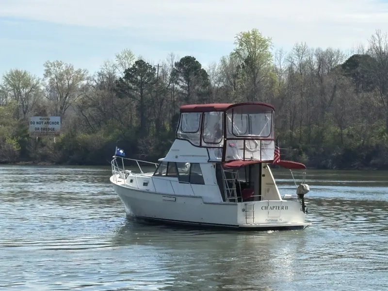 Slide: The Image of 1983 Mainship 34 Mark III boat on calm river. - 5