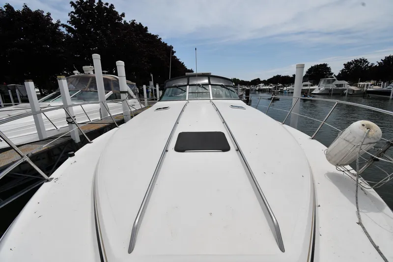 Slide: The Image of 1994 Sea Ray 400 Express Cruiser docked at marina, showcasing sleek design and spacious deck. - 5