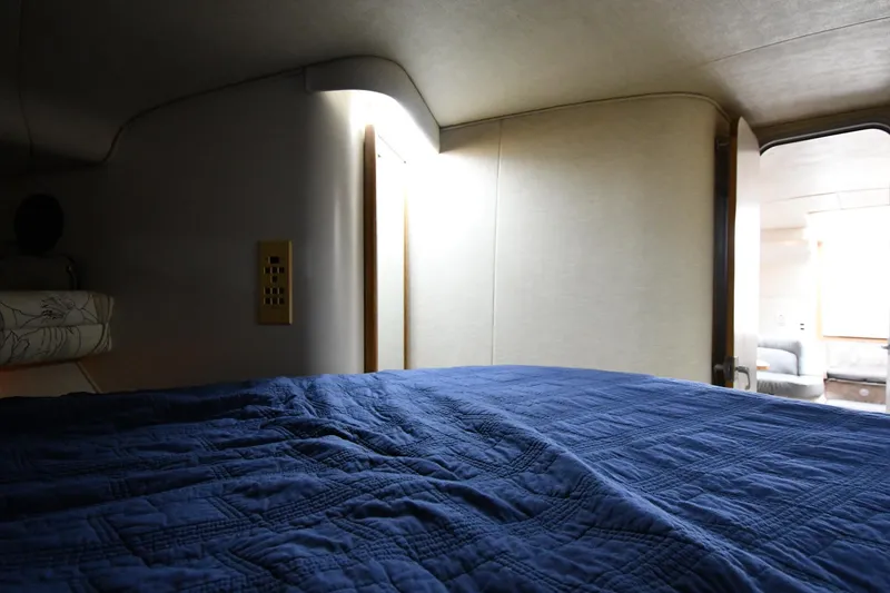 Slide: The Image of Cozy cabin interior of 1994 Sea Ray 400 Express Cruiser with blue bedding. - 29