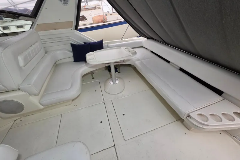 Slide: The Image of Interior of 1994 Sea Ray 400 Express Cruiser with white seating and table. - 11