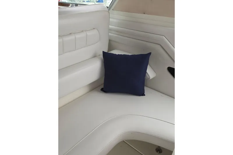 Slide: The Image of White leather seating with a navy cushion on a 1994 Sea Ray 400 Express Cruiser. - 12