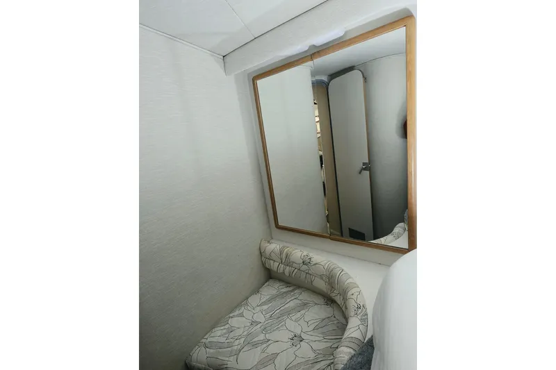 Slide: The Image of Interior of 1994 Sea Ray 400 Express Cruiser with floral-patterned seating and wall mirror. - 15