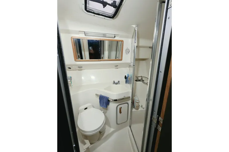 Slide: The Image of Bathroom interior of 1994 Sea Ray 400 Express Cruiser, featuring toilet, sink, and mirror. - 18