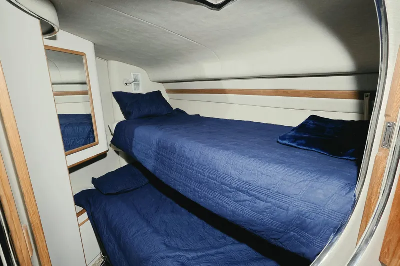 Slide: The Image of Interior cabin of 1994 Sea Ray 400 Express Cruiser with blue bunk beds. - 19