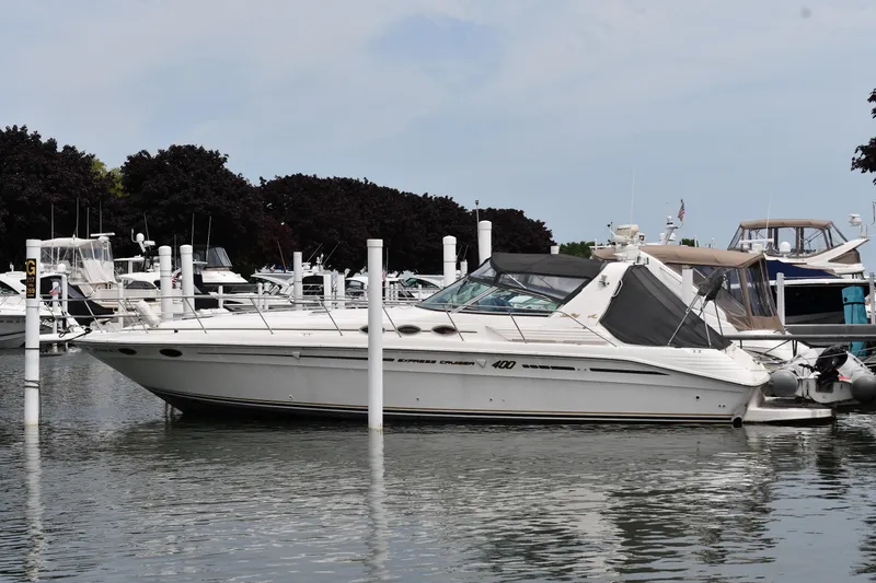 The Image of 1994 Sea Ray 400 Express Cruiser docked at marina, surrounded by other boats. - 0