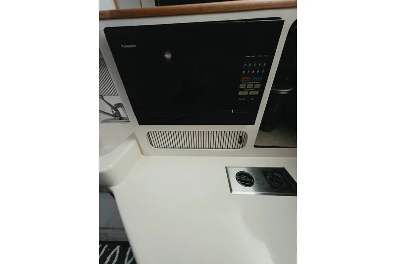 Slide: The Image of 1994 Sea Ray 400 Express Cruiser interior with Panasonic microwave and sleek countertop design. - 22