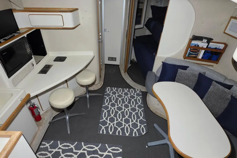 Slide: The Image of Interior of a 1994 Sea Ray 400 Express Cruiser with modern seating and kitchenette. - 24