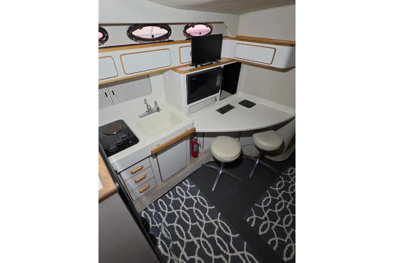 Slide: The Image of Interior of 1994 Sea Ray 400 Express Cruiser with kitchenette and seating area. - 25
