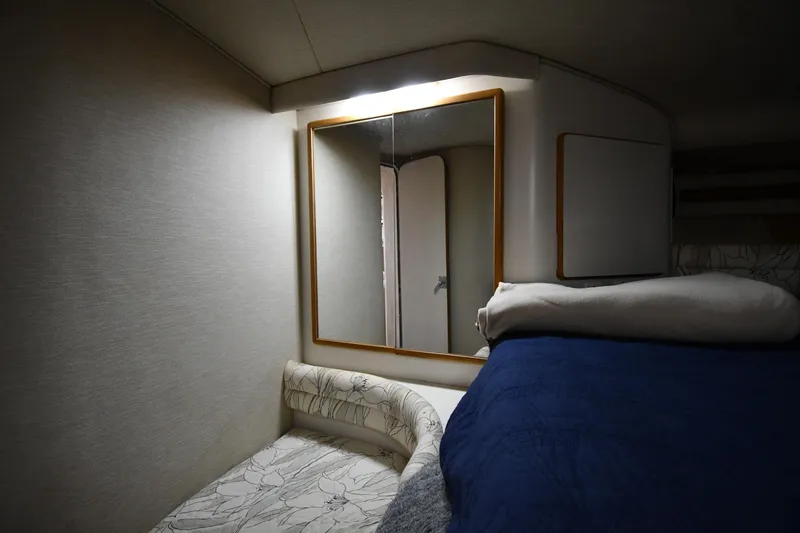 Slide: The Image of Interior cabin of 1994 Sea Ray 400 Express Cruiser with mirror and bedding. - 27