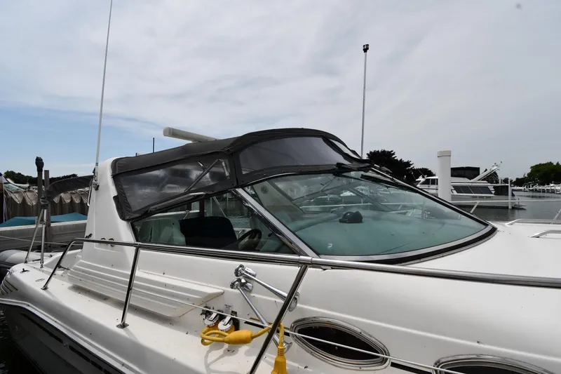 Slide: The Image of 1994 Sea Ray 400 Express Cruiser docked at marina, featuring sleek design and spacious deck. - 3