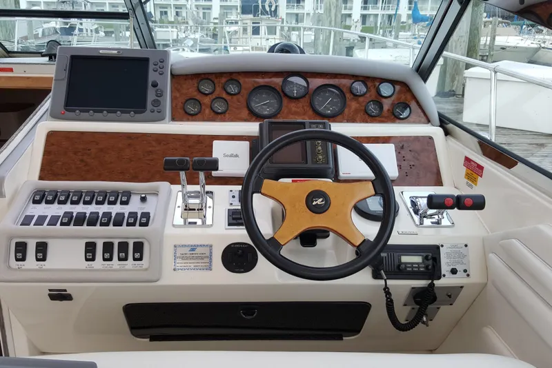 Slide: The Image of 1994 Sea Ray 400 Express Cruiser helm with steering wheel, gauges, and navigation controls. - 8