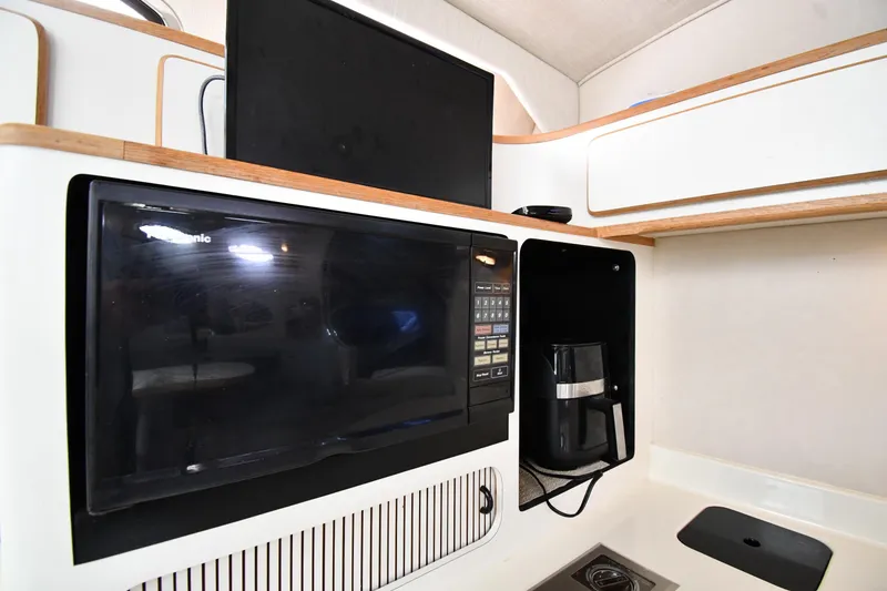 Slide: The Image of 1994 Sea Ray 400 Express Cruiser kitchen with microwave and coffee maker. - 40