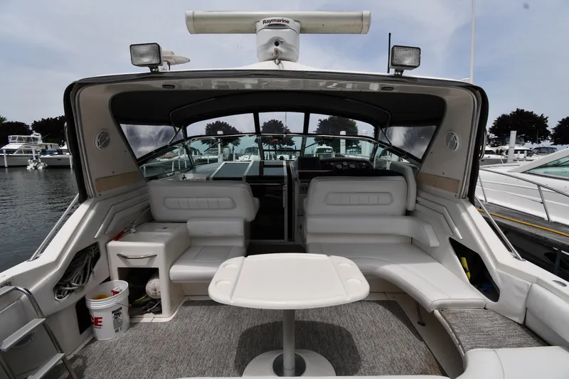 Slide: The Image of 1994 Sea Ray 400 Express Cruiser interior with seating and table, docked at marina. - 7