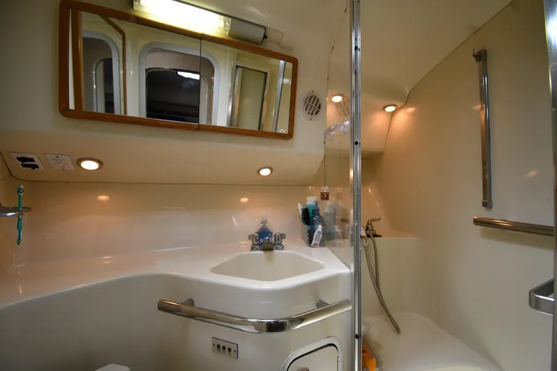 Slide: The Image of Bathroom interior of 1994 Sea Ray 400 Express Cruiser with sink, mirror, and shower. - 36