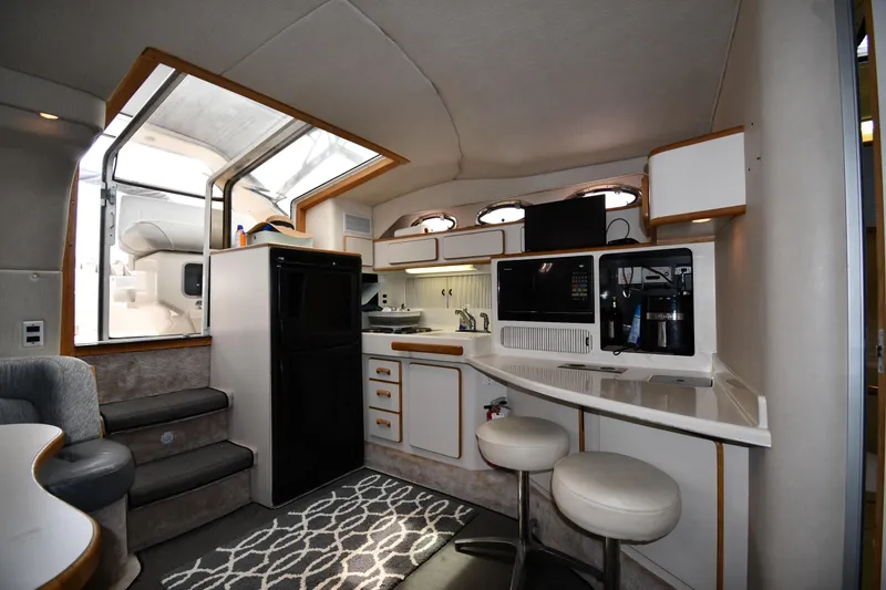 Slide: The Image of Interior of 1994 Sea Ray 400 Express Cruiser with kitchen and seating area. - 32