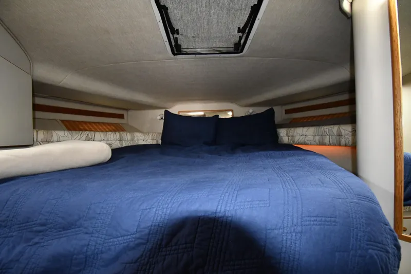 Slide: The Image of Cozy cabin interior of 1994 Sea Ray 400 Express Cruiser with blue bedding. - 25