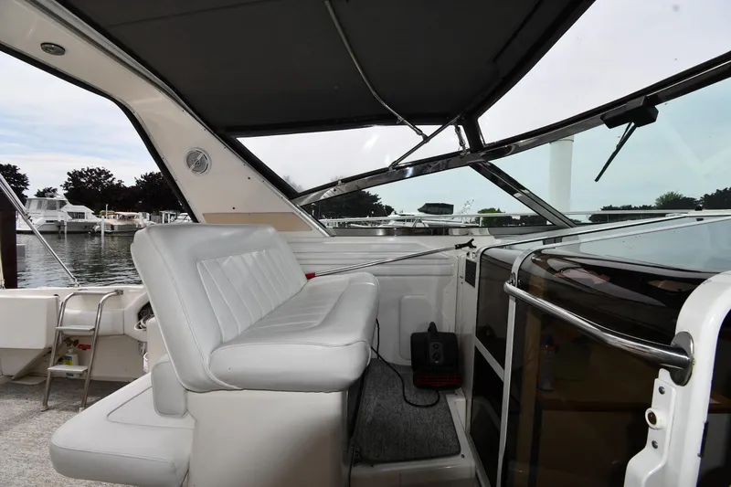 Slide: The Image of 1994 Sea Ray 400 Express Cruiser interior with white seating and marina view. - 15