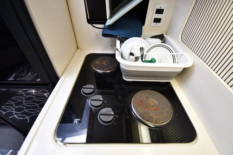 Slide: The Image of Compact kitchen area in a 1994 Sea Ray 400 Express Cruiser with stove and dish rack. - 38