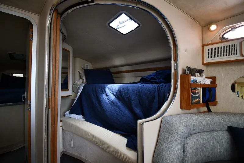 Slide: The Image of Interior cabin of a 1994 Sea Ray 400 Express Cruiser with cozy bedding and wooden accents. - 34