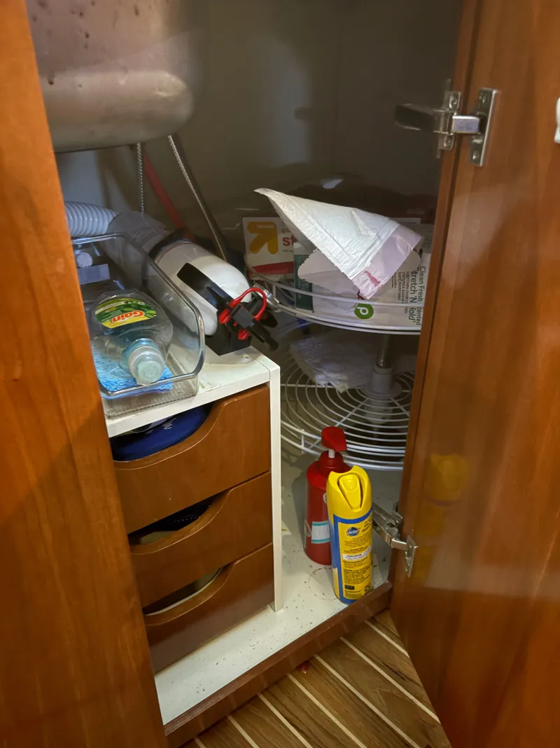 Slide: The Image of Kitchen cabinet on a 2007 Meridian 459 Motoryacht with cleaning supplies and household items. - 39
