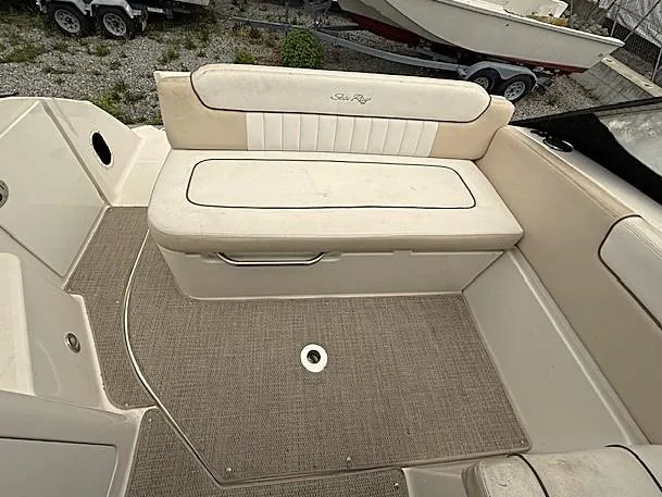 Slide: The Image of 2013 Sea Ray 260 Sundancer boat interior with beige seating and carpeted floor. - 10